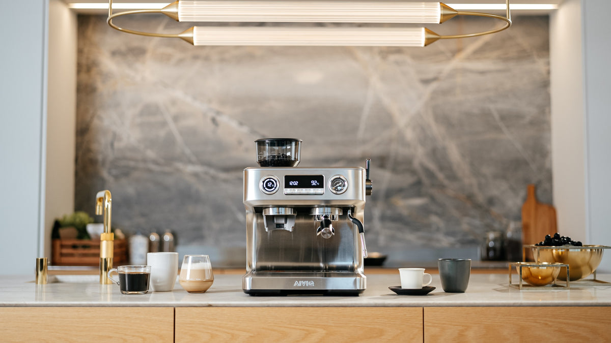 AIVIQ Aspire Advanced espressomaskine i børstet rustfrit stål på et køkken med marmorvæg