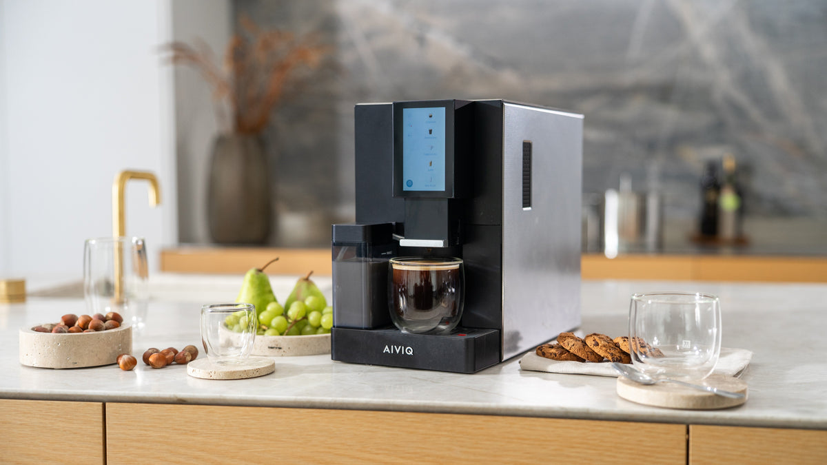 AIVIQ Lumina Pro fuldautomatisk espressomaskine på et køkkenbord med frugt og kaffekop