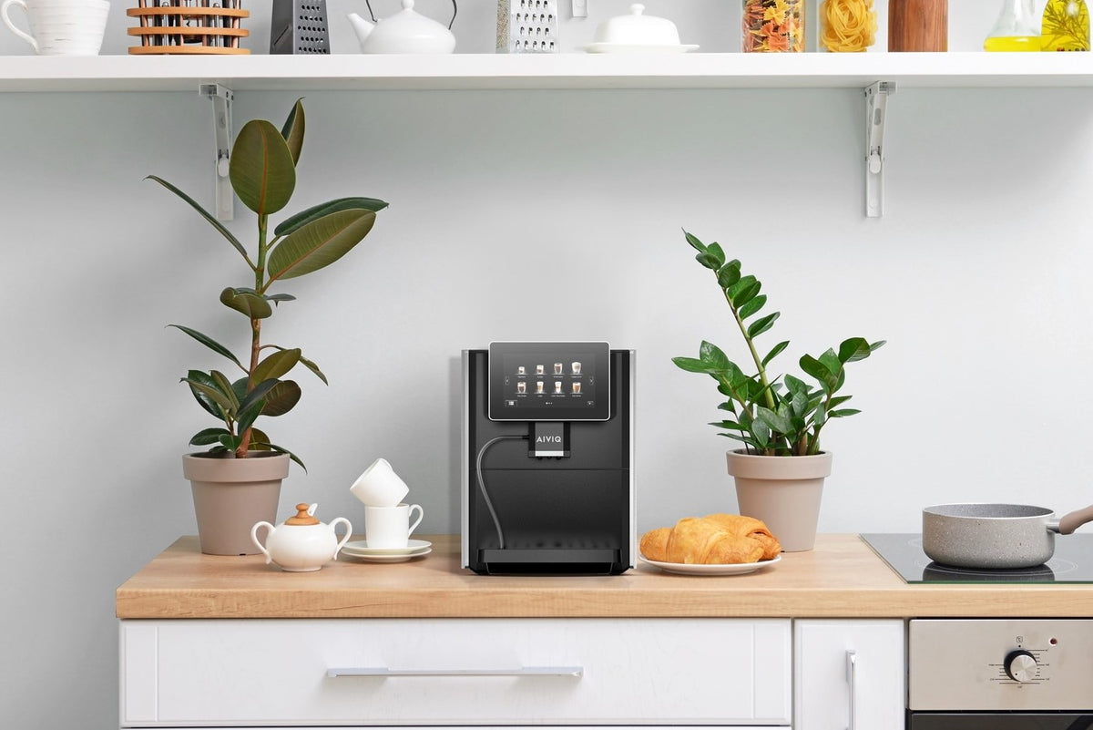 AIVIQ AEM-101S fuldautomatisk espressomaskine i et lyst køkken med planter og croissant