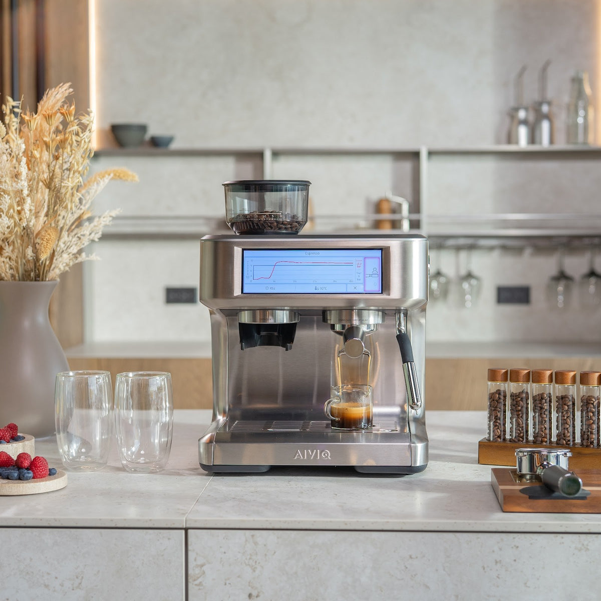 Aspire Expert på en lys bordplade i et køkken med træpaneler og åbne hylder. En espresso løber ned i et lille målebæger, mens skærmen viser en trykkurve.