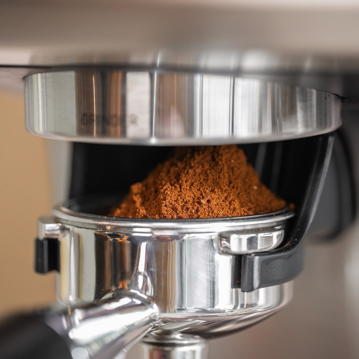 Friskmalet kaffe i en top i portafiltret, der står i kværnholderen under kværnen på Aspire Expert. Vægten sidder i kværnholderen.
