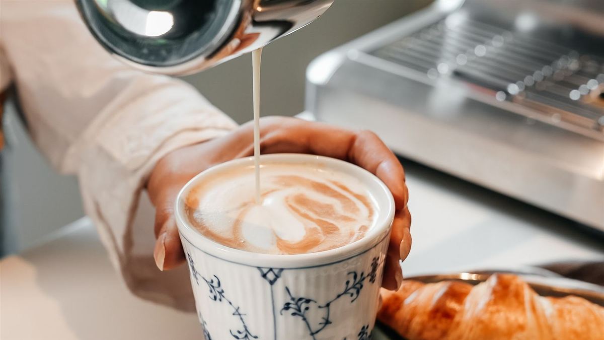 Mælk, der hældes i en cappuccino