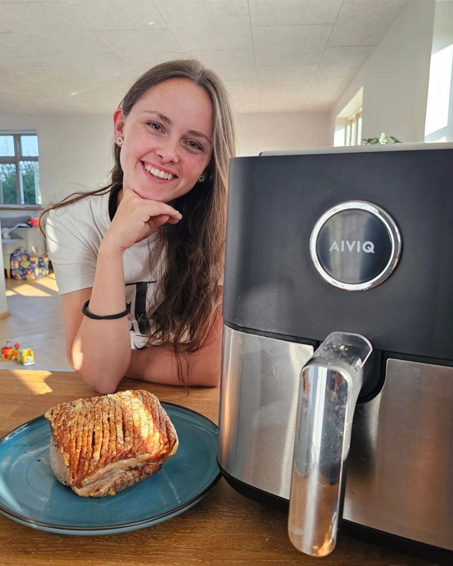Kvinde ved spisebordet med airfryer og flæskesteg